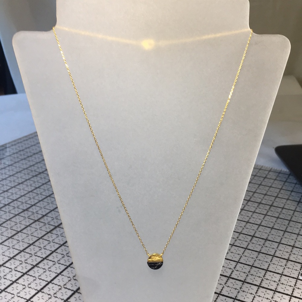 “Must Have” gold circle with half stone detail on delicate gold chain.